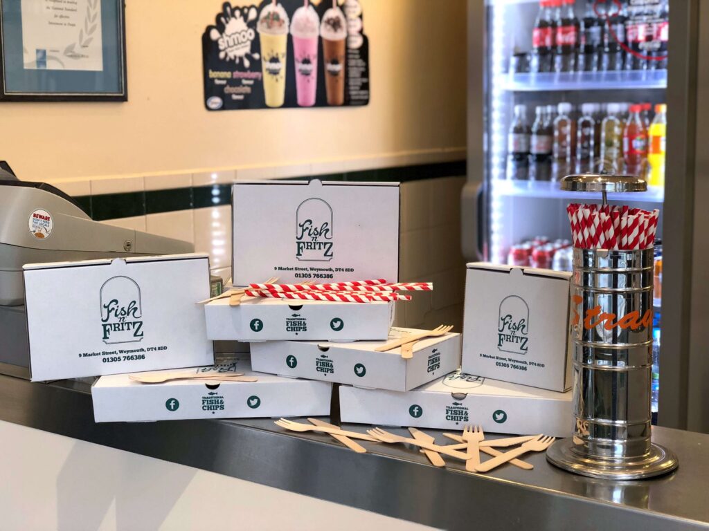 Environmentally friendly boxes, wooden forks and paper straws on the counter at Fish 'n' Fritz